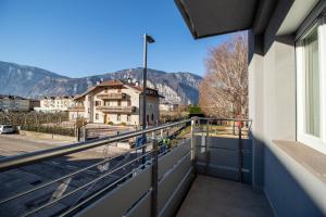 a balcony with a view of a building and mountains at Alessia Living in San Michele allʼAdige
