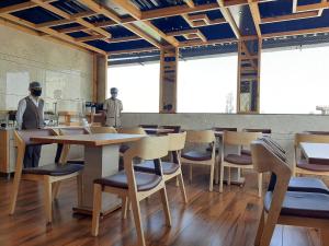 a restaurant with wooden tables and chairs in a room at Hotel Royal Treat Surat in Surat