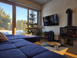 a living room with two blue couches and a christmas tree at Warmińska Polana - Nowy, całoroczny dom na 2 ha łące dla 8 osób - Gietrzwałd in Gietrzwałd