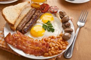 a plate of breakfast food with eggs bacon beans and toast at Castle Colombo in Piliyandala