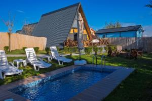 a swimming pool with white chairs and a table at AYBELYA TATİL KÖYÜ in Bafra