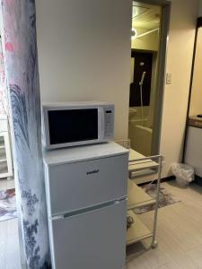 a microwave sitting on top of a refrigerator at Peace Wing 6D in Kami-nagarekawachō