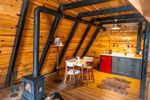 a kitchen and dining room with a stove in a log cabin at AYBELYA TATİL KÖYÜ in Bafra