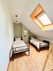 two beds in a attic bedroom with a skylight at Bright loft-style duplex 6 people Dunkirk in Coudekerque-Branche