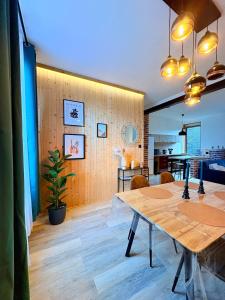 a dining room with a table and a kitchen at Bright loft-style duplex 6 people Dunkirk in Coudekerque-Branche