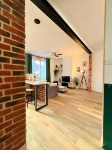an open living room with a brick wall at Bright loft-style duplex 6 people Dunkirk in Coudekerque-Branche