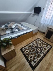 a bedroom with a bed and a rug on the floor at Cabana Geta&Mircea in Beclean