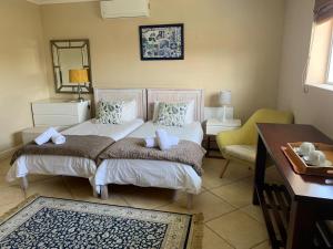 a bedroom with two beds and a desk and a mirror at Carmel Huys in Cape Town +62 photos