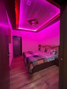 a bedroom with pink lights on the ceiling at Hotel Raghav in Orchha