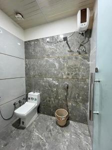 a bathroom with a shower and a toilet and a sink at Hotel Raghav in Orchha