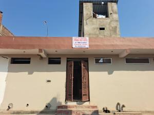 a building with a window and a sign on it at Hotel Raghav in Orchha