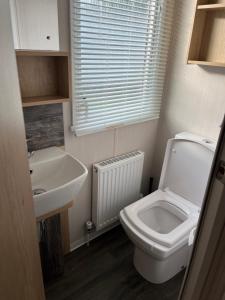 a small bathroom with a toilet and a sink at 23 The Brambles - Haven Cleethorpes Beach in Humberston +9 photos