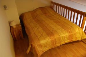 a bed with a yellow comforter in a room at Moonlight 213 Visit Levi in Levi