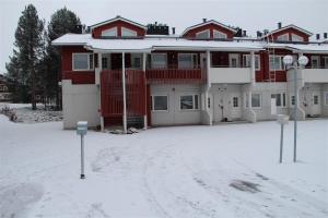 a large red building in the snow with two parking meters at Moonlight 213 Visit Levi in Levi