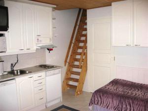 a kitchen with white cabinets and a spiral staircase at Moonlight 213 Visit Levi in Levi