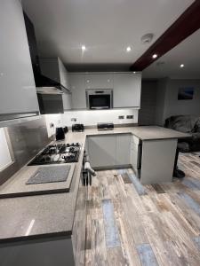 a kitchen with white cabinets and a stove top oven at Longshore Drift in Woodhorn