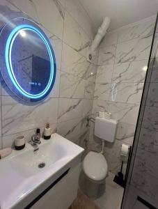 a bathroom with a white sink and a mirror at Stan Krndija - Tesanj in Tešanj