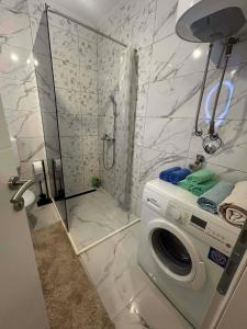 a bathroom with a washing machine and a shower at Stan Krndija - Tesanj in Tešanj