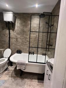a bathroom with a tub and a toilet and a sink at Longshore Drift in Woodhorn +14 photos