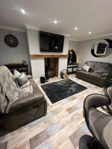 a living room with two couches and a flat screen tv at Longshore Drift in Woodhorn