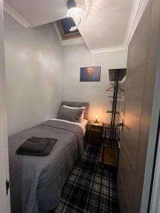 a small bedroom with a bed and a lamp at Longshore Drift in Woodhorn