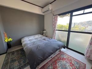 a bedroom with a bed and a large window at Peace Wing 6D in Kami-nagarekawachō