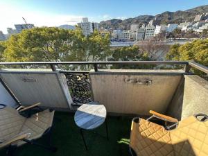 a balcony with chairs and a table and a view of a city at Peace Wing 6D in Kami-nagarekawachō