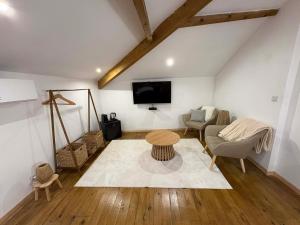 a living room with a table and a tv at Le Jardin d'Elusa in Eauze