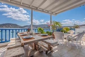 a table and chairs on a patio with a view of the ocean at Heliotropio Studios & Apartments in Pollonia