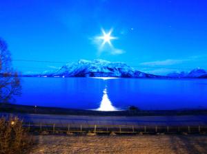 a star in the sky over a lake at night at Solheim Fritidsgård in Svensby