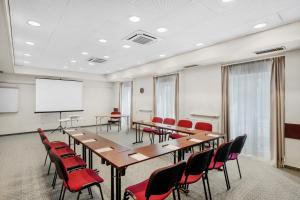 a conference room with tables and chairs and a whiteboard at Danubius Hotel Raba in Győr