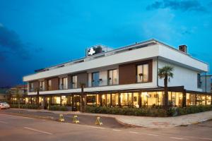a white building with palm trees in front of it at Casa Bianca Hotel in Denizli