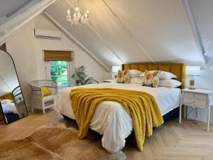 a bedroom with a large bed with a yellow blanket on it at Falcon House Luxury Apartments in Cape Town