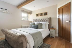 a bedroom with a large bed with a large headboard at 1 Force Mill Barn - Ridgestone in Ulverston