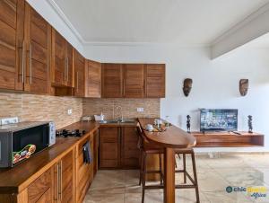 a kitchen with wooden cabinets and a wooden table at Chic studio with amazing view in Yaoundé
