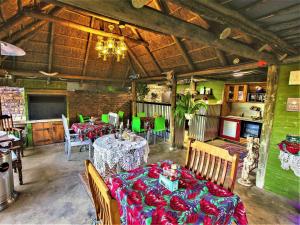 a dining room with two tables and green walls at The Ranch Guesthouse in Potchefstroom
