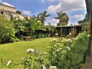 a garden with white flowers in a yard at The Ranch Guesthouse in Potchefstroom