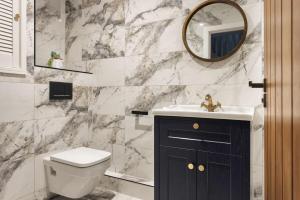 a bathroom with a sink and a toilet and a mirror at 1 Force Mill Barn - Ridgestone in Ulverston +33 photos