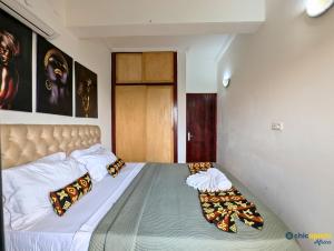 a bedroom with a large bed with two pillows at Chic studio with amazing view in Yaoundé