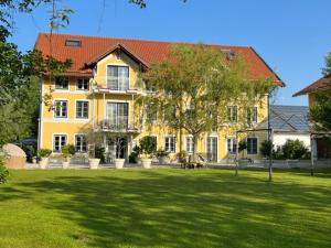 a large yellow house with a large grass yard at Landgut zur Mühle in Dorfen
