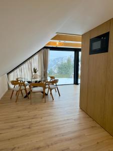 a dining room with a table and chairs on a wooden floor at Apartament Świerkowa Osada in Istebna