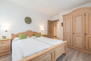 a bedroom with a large bed and a wooden cabinet at Ferienwohnung Eder in Gais