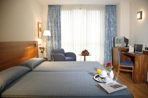 a hotel room with a bed and a desk and a television at Hotel Mieres del Camino in Mieres +27 photos