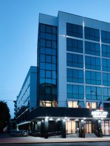 a tall building with a car parked in front of it at New City Hotel & Restaurant Niš in Niš