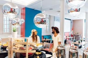 a man and woman standing behind a counter with food at Stay Hotel Lisboa Centro Chiado in Lisbon