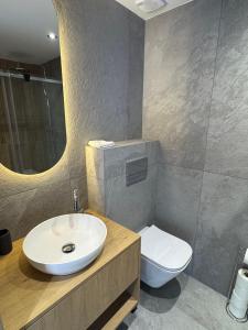 a bathroom with a sink and a toilet and a mirror at Apartament Świerkowa Osada in Istebna +10 photos