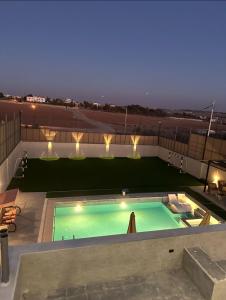 a swimming pool on top of a building at night at شاليه الدرة Durra Chalet in Amman