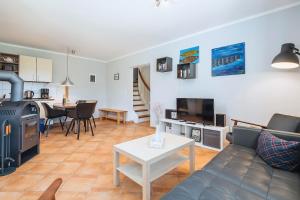 a living room with a couch and a table and a kitchen at Strandgut in Börgerende-Rethwisch
