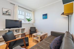 a living room with a couch and a tv at Strandgut in Börgerende-Rethwisch