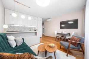 a living room with a green couch and a table at Modern old town apartment in Bratislava